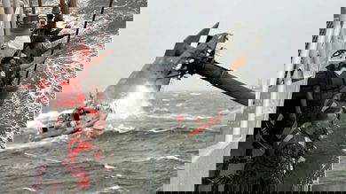 Coast Guard crew rescuing people from capsized commercial lift boat Seacor Power.
