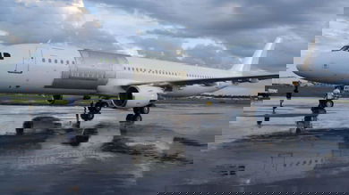 A white plane with no markings and an outline for cutting a large cargo door in side.