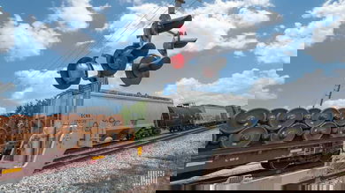 A photograph of a train at a railroad crossing.