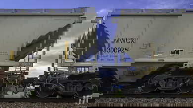 A photograph of hopper cars on a train track.