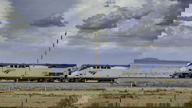 A photograph of an Amtrak train traveling through an open field.