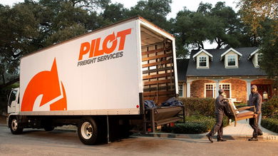 Drivers unload furniture from a truck to bring in a home. Pilot Freight is the company.