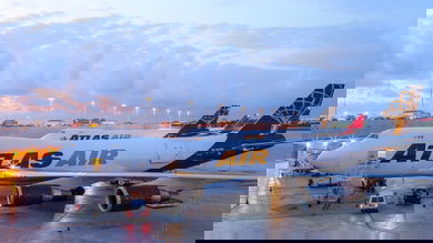 Atlas Air jumbo jets with blue and gold lettering sit on tarmac at dawn.