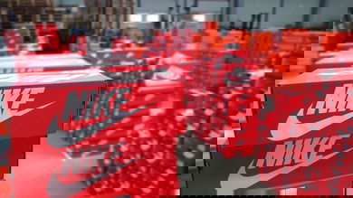 Stacks of red Nike shoe boxes in a warehouse.