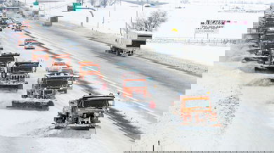 Cars, tractor-trailers and plow trucks on a snowy Colorado road.