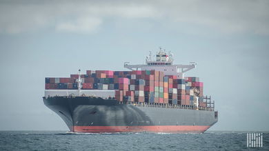 A container ship travels on the water to illustrate an article about cybercriminals selling access to shipping firms