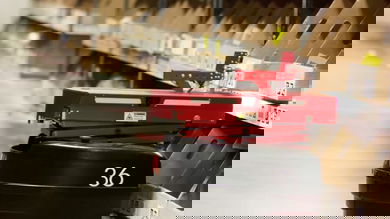 Red warehouse robot picks item off shelf