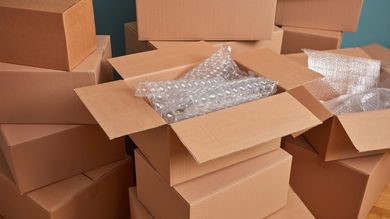 Several shipping boxes are stacked up with bubble wrap packaging inside.