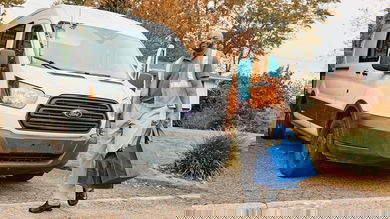 Man walking in front of van with 2 packages