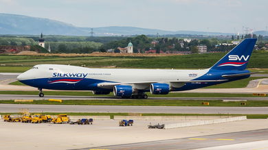 A white and blue Silk Way West Airlines jet at an airport.