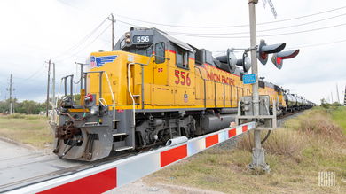 A freight train passes by a railroad crossing.
