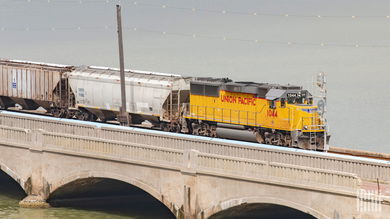 A train hauling railcars crosses a bridge.