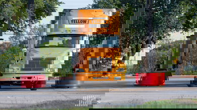 A Yellow truck at a fuel pump