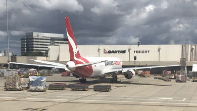 A red-tailed Qantas Freight jet in front of the Qantas Freight airport terminal.