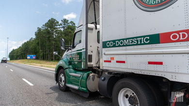 An Old Dominion tractor pulling a trailer on a highway