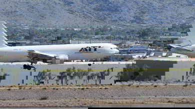 A white ATI cargo jet seen about to land at a desert airport.