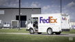 A FedEx Ground delivery van drives into a parcel terminal.