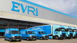 Light blue Evri delivery vans and heavy trucks at an Evri warehouse dock.