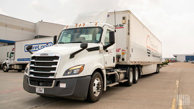 A white Forward Air truck pulling a Forward Air trailer at an air cargo facility