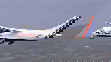 A Purolator cargo plane flies under propeller power at low atltitude.