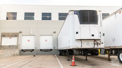 A refrigerated trailer docked at a warehouse