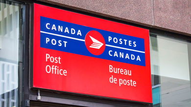 Red-and-blue Canada Post sign above a postal office.
