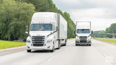 Two white tractor-trailers on a highway