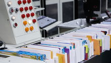 Letters lined up in a postal service sorting machine.