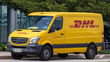 A bright-yellow DHL delivery van parked on a street.