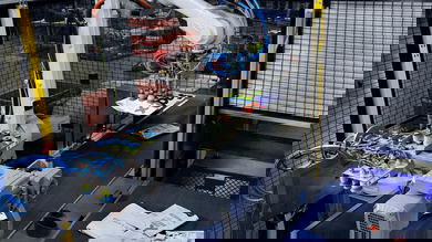 A robotics arm helps sort packages on a FedEx package conveyor.