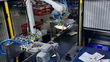 A robotics arm helps sort packages on a FedEx package conveyor.