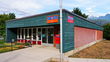 A rural Canada Post post office. Square building with mountains in the background.
