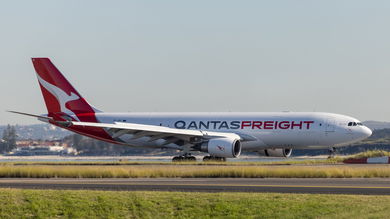 A red-tailed Qantas Freight cargo jet on the runway.