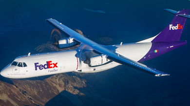 A small purple-and-white FedEx plane powered by propeller turbine engines in the air as seen from above.